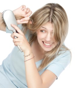 Beautiful young woman combing her hair